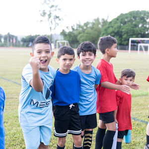 Niños sonriendo en uniformes de fútbol y campo; Escuela De Futbol Bravos De Cidra.