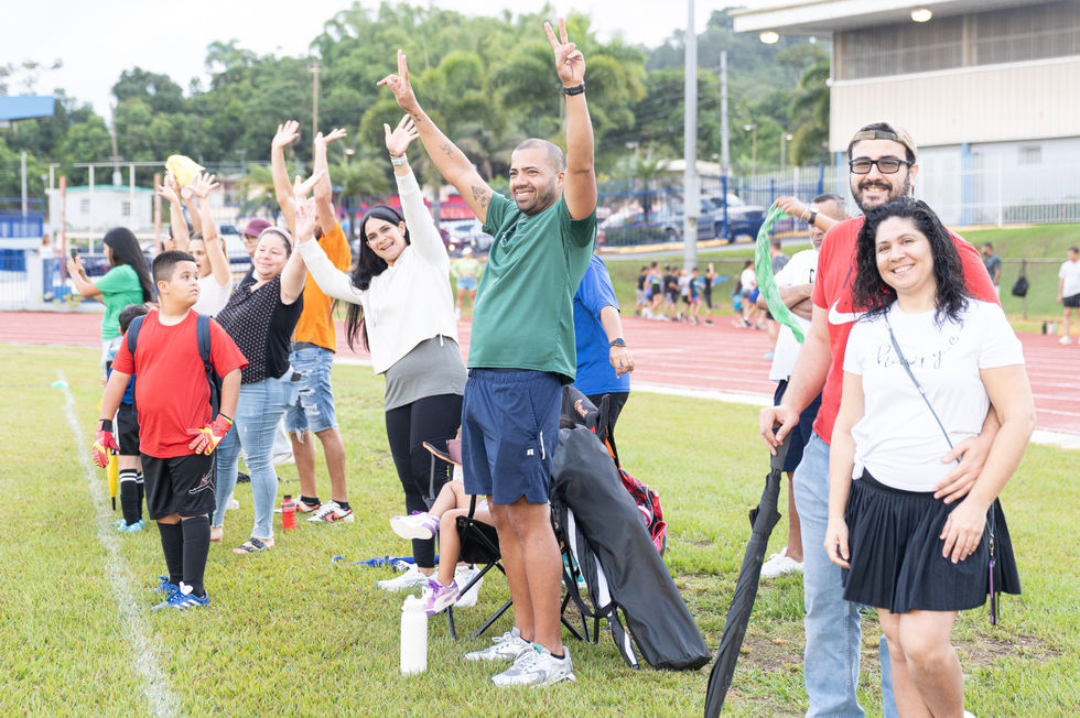 Group of people celebrating on a field, Escuela De Futbol Bravos De Cidra.