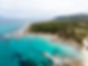 aegean-sea-coast-with-blue-transparent-water-greenery-around-rocks-bushes-trees-view-from-