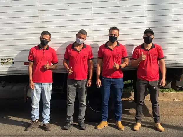 Equipe de profissionais da Uberlândia Frete, uniformizada e pronta para realizar seu transporte com segurança.