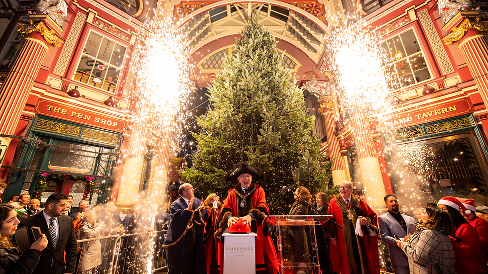Celebration at Leadenhall Market with a large Christmas tree, sparklers, and a person in ceremonial attire pressing a button. Festive mood.