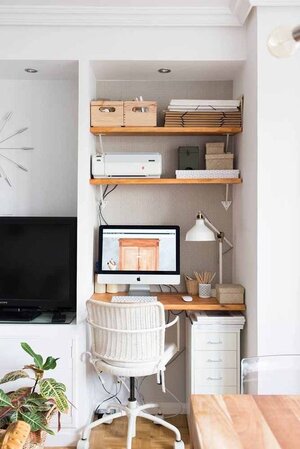 Modern home office setup with computer, shelves, and minimal decor