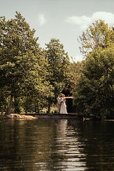 Porträtt bilde på brudparet vid dammen på Åmunds Frukt och Vingård