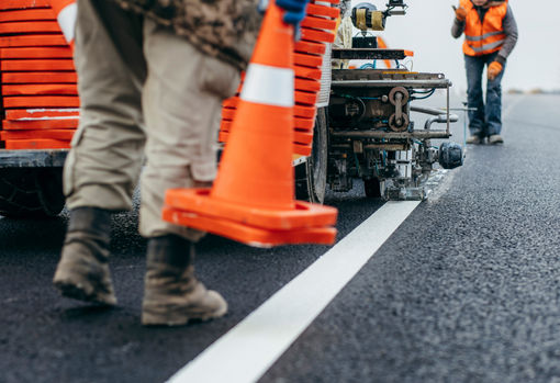 Road striping and pavement markings work with cones in active work zone