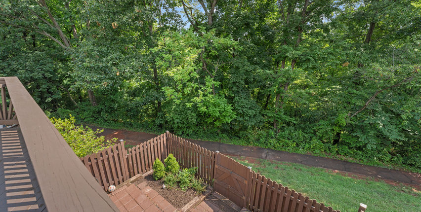 View from the deck over the fenced yard and walking path to the woods beyond