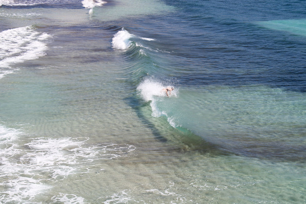 Man catching waves in Cala Tarida, Ibiza