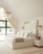 Luxurious white bedroom with large upholstered bed