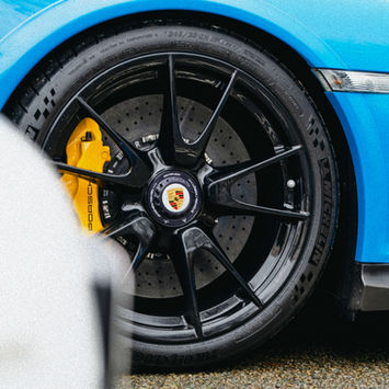 Porsche wheel with black rims and yellow brake calipers