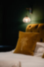 Bed with golden palm tree pillow and wall lamp