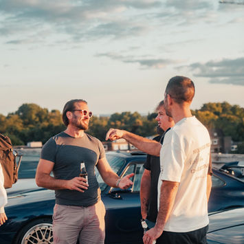 Men talking outdoors at a Cars & Chai automotive meetup