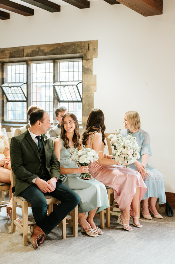 wedding guests talking to each other during ceremony