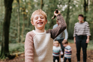 child smiling at camera waving stick