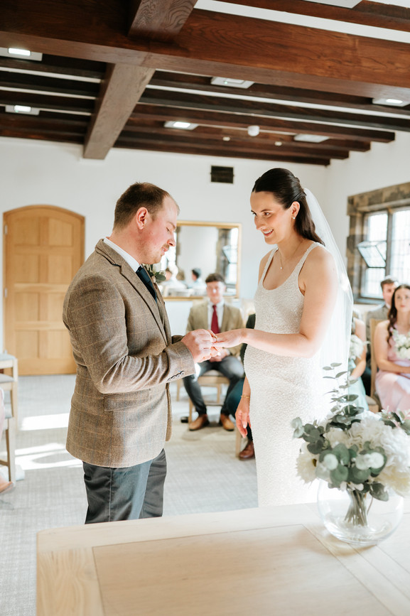 exchange of rings during wedding ceremony, wood beamed ceiling 