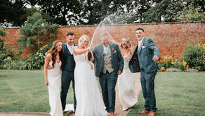 Wedding party spraying champagne in walled garden