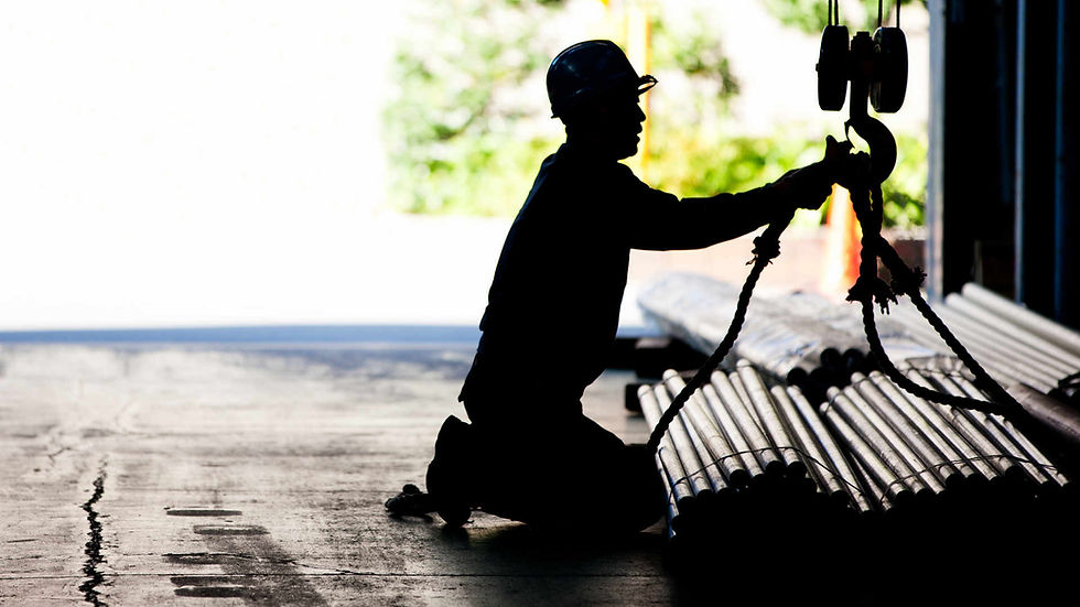 A working person is handling pipes and a crane