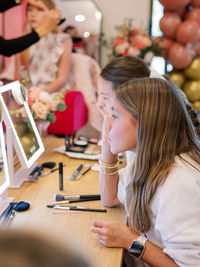 Girls applying makeup at glam party