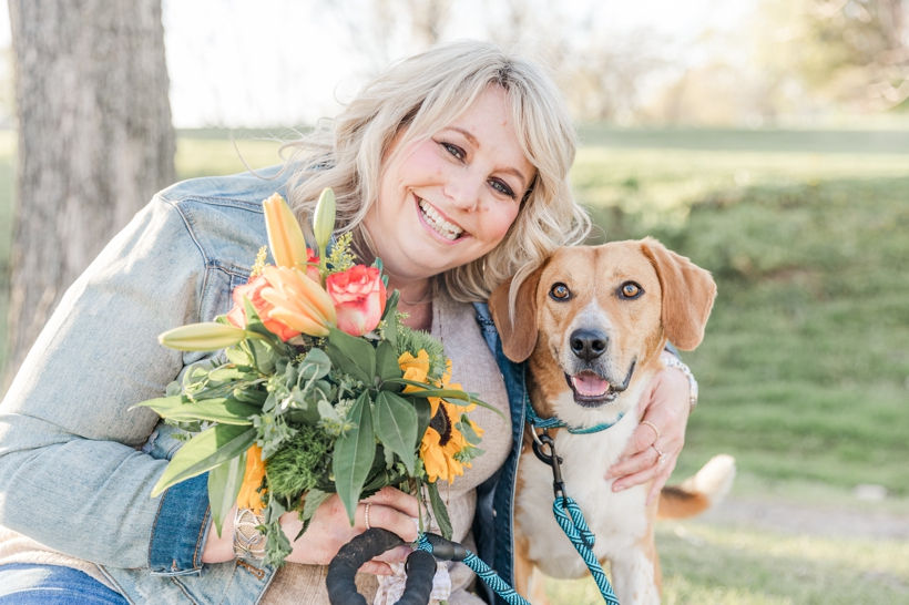 Spring mini portrait session at Ellington Agricultural Center in Nashville, Tennessee with Family and Newborn Photographer Janet Henry Photography. Headshots of a woman holding flowers with her adopted dog from Proverbs 12:10 Animal Rescue of Middle Tennessee.