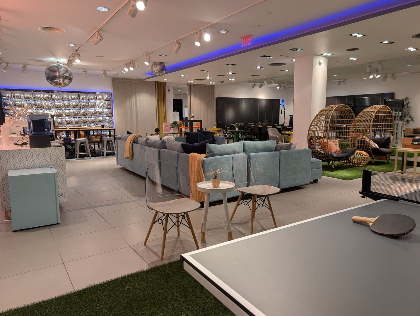 Modern open space showcases lounge seating, tables, and a ping pong table.