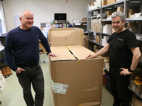 Karene fra Nautus poserer ved en ferdig pakket leveranse