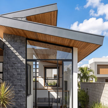 Projeto residencial M | K em Mogi das Cruzes, com fachada contemporânea, grandes aberturas em vidro, pedra natural, estrutura metálica e integração entre interiores, iluminação natural e área externa.