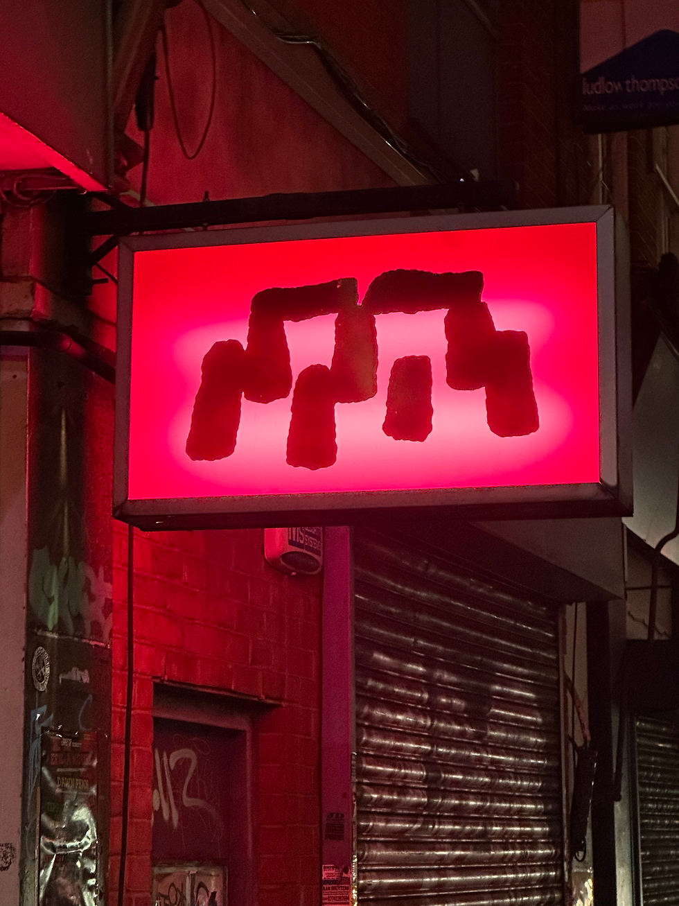 Dash the Henge's sign glowing like a fixed star at night