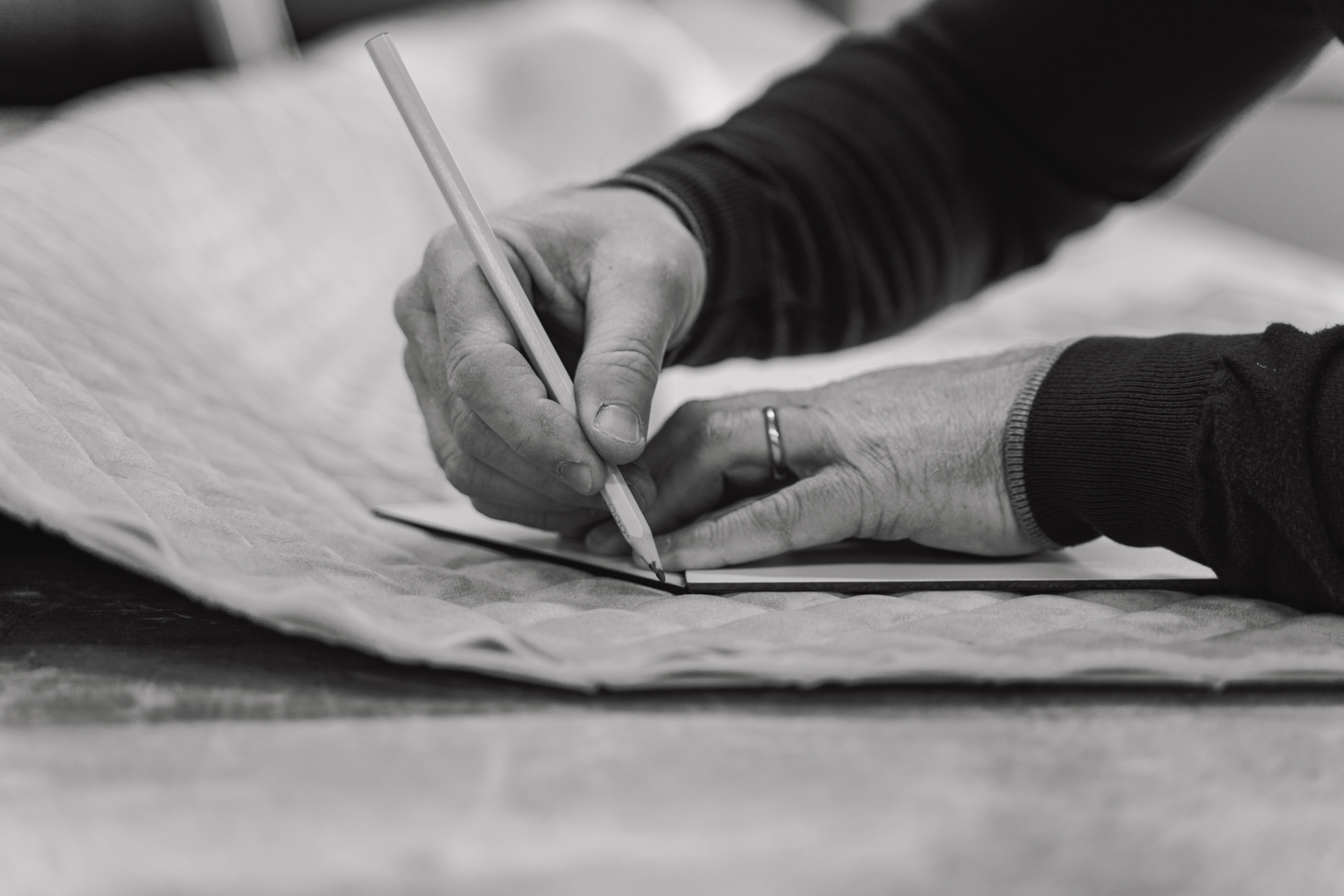 Ampio soggiorno con divano bianco e cuscini gialli e blu, tende bianche.