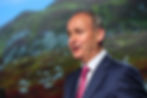 Man in suit in front of screen showing upland bog