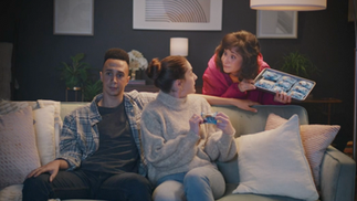 Actor Laura Doman in a TV commercial presents a tray of Bobo's to a young couple sitting on a couch.