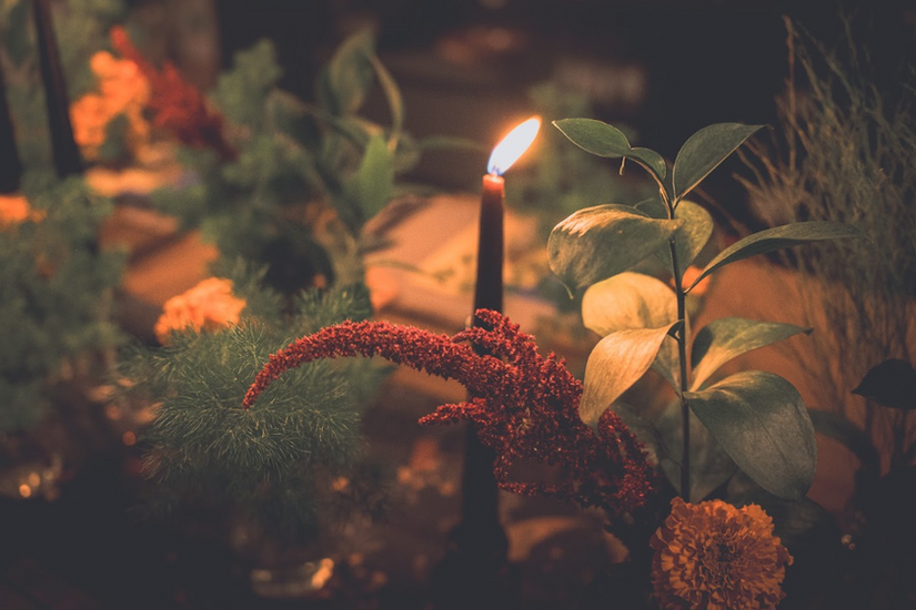 Candlelit floral centerpiece with seasonal blooms creating a cozy and intimate dining atmosphere.