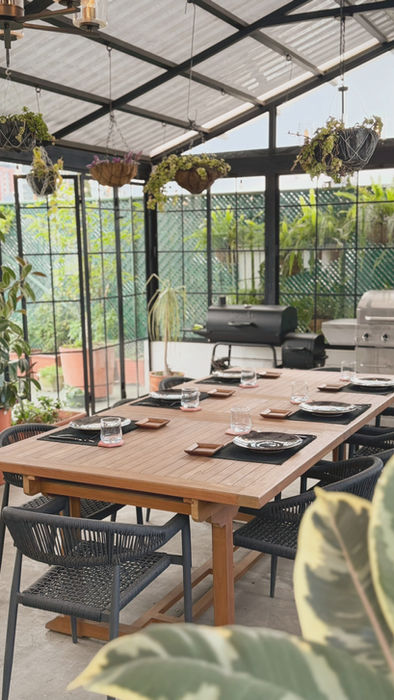 Large communal dining table surrounded by plants inside Botanical Rooftop.