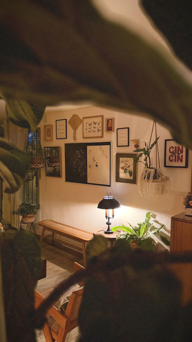 Handcrafted lamp framed by plants inside The Greenhouse Residence