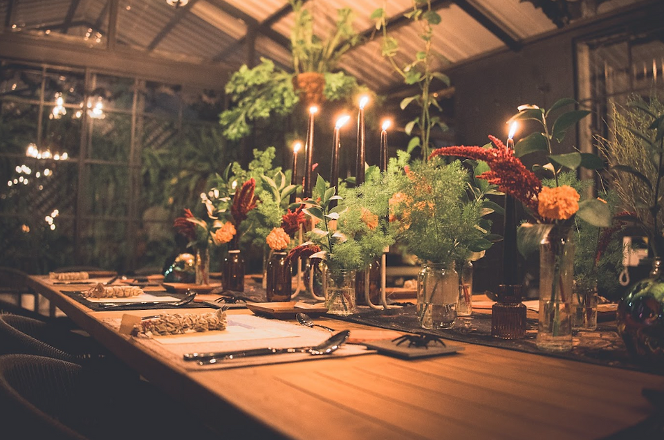 A candlelit Halloween dinner table at Botanical Rooftop, featuring seasonal flowers, thoughtful table styling and an intimate atmosphere designed for meaningful gatherings.