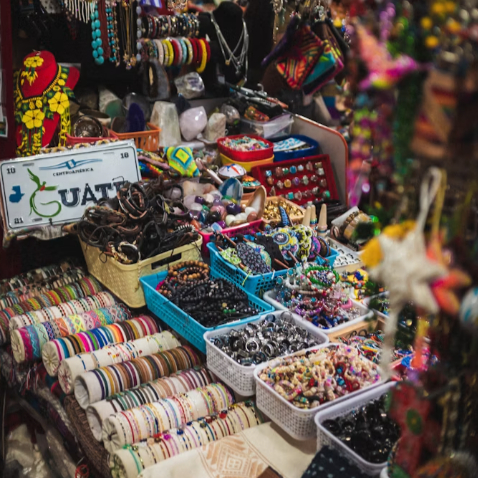 A colorful artisan market showcasing handcrafted jewelry, textiles and locally made souvenirs from Guatemala.