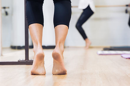 Bare feet at studio at the barre ready for class.