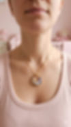 collier souvenir personnalisé original avec mèche de cheveux porté par une femme dans une chambre de bébé