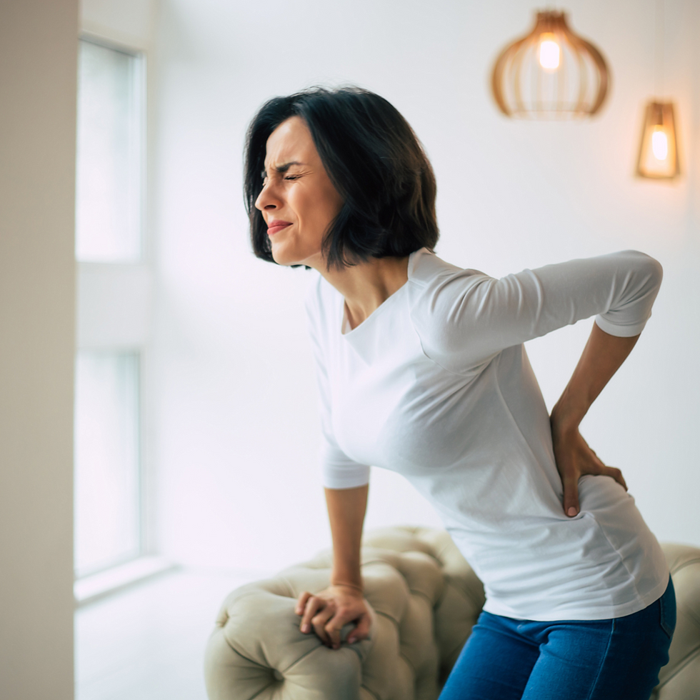 person holding lower back in pain