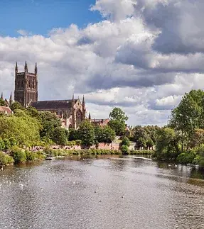 image of a river with trees on the edge with a church in the background