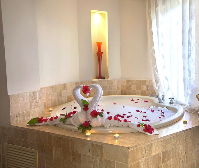 Jacuzzi with Love Theme, two swans made of white towels on the edge of the jacuzzi; a red vase