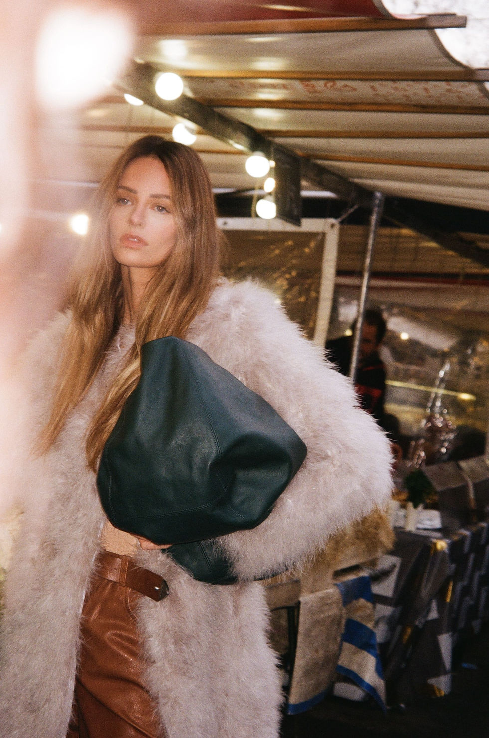 Model Raelyn Wierzchowski styled by Tania Tuka, walking through a vibrant Parisian market, captured by photographer Ali Ghorbani Moghaddam – an intimate portrayal of everyday life in Paris with rich textures and candid expressions