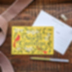 North Carolina postcard shown front and back, on wood surface surrounded by a gold pen and pink ribbon