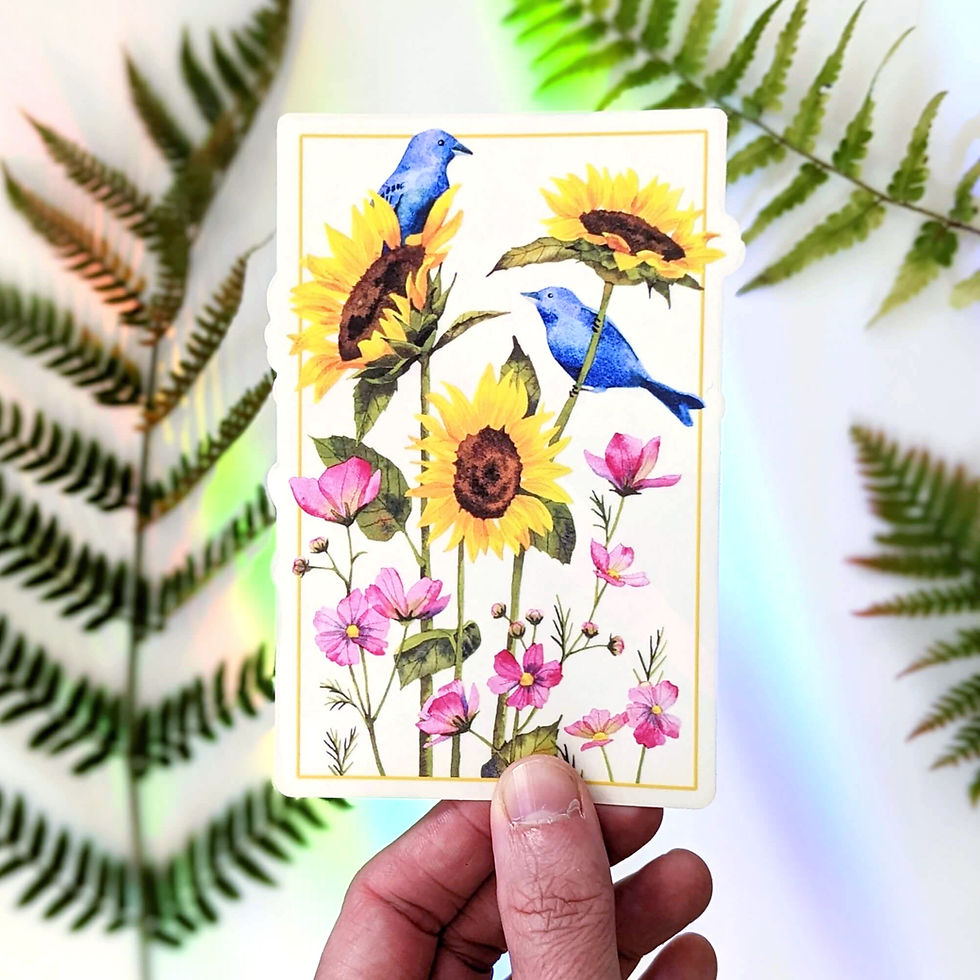 A hand holds the watercolor prismatic suncatcher. Rainbows and ferns are in the background