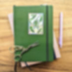 The sticker is shown on a notebook, with decorative scissors and pen for size.
