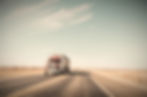 A%20red%20semi%20truck%20driving%20along%20a%20West%20Texas%20road_edited.jpg