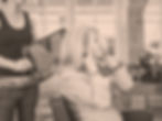 a client couches her hair while a hairdressers holds a mirror to the back 