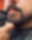 close up of a hand holding a trimmer being used on a mans beard