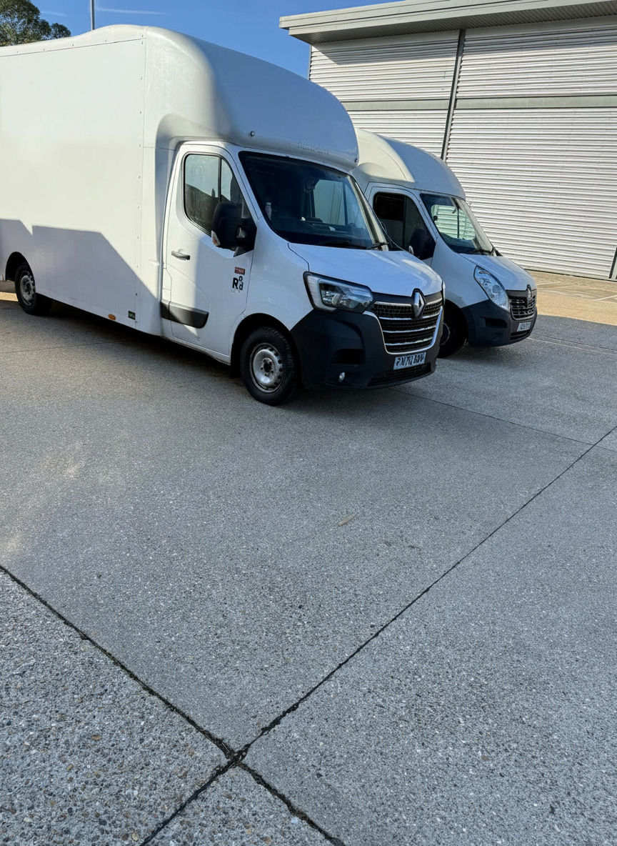Eye-level view of a removal crew loading wrapped furniture into a Luton vehicle