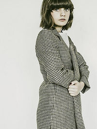 photo-portrait-fille-brunette-avec-une-frange-manteau-à-carreaux