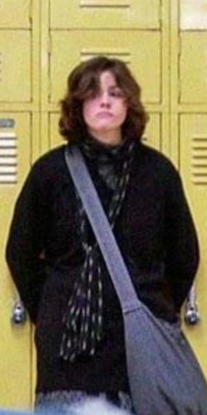 Alyson Reynolds (Ally Sheedy) standing against a row of yellow lockers