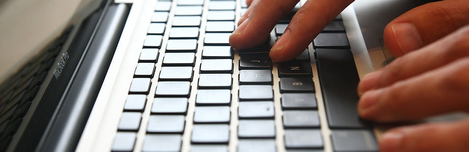 Close-up of hands typing on a laptop – contact J.C Carpentry & Design to request a quote or consultation.