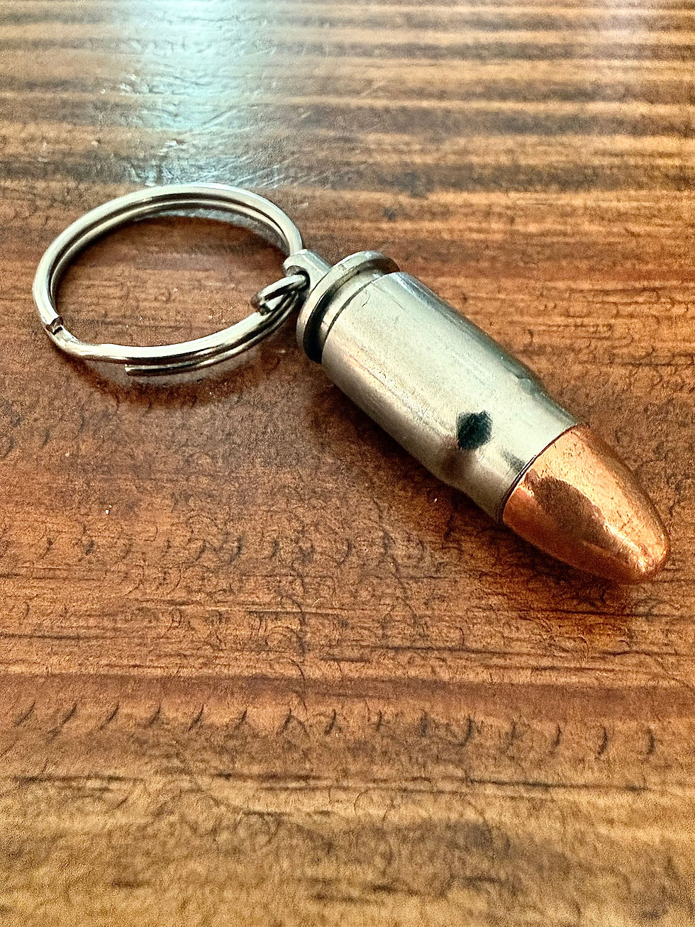 Thumbnail: .357 SIG nickel bullet keychain made from an authentic once-fired cartridge case on a rustic wood background.